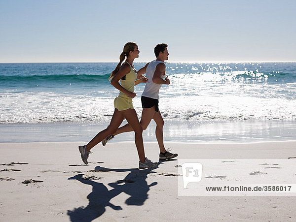 Young couple jogging on beach