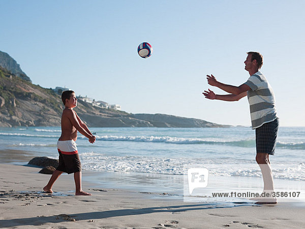 Father and son playing ball on a beach