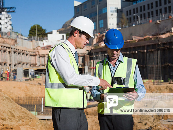 Mature men with clipboard on construction site