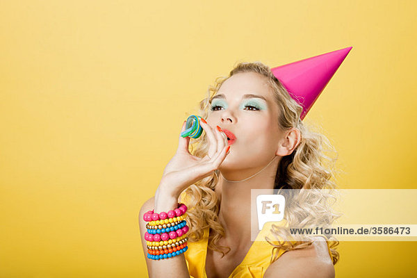 Junge Frau mit Partyhut und Party-Streamer
