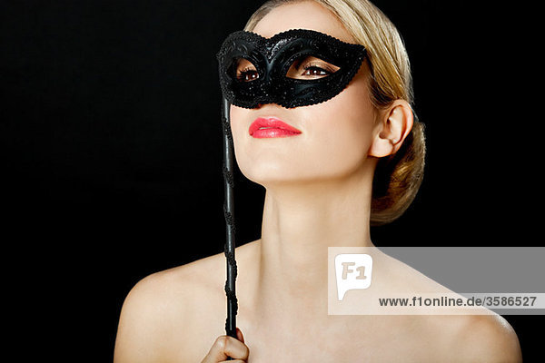 Junge blonde Frau mit schwarzer Maske
