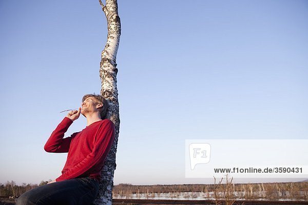 Man leaning back on tree