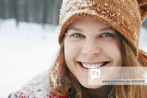 Lächelnde junge Frau im Schnee