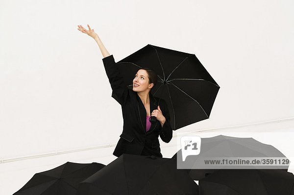 Glückliche Frauen mit Regenschirm fühlen sich nach Regen an