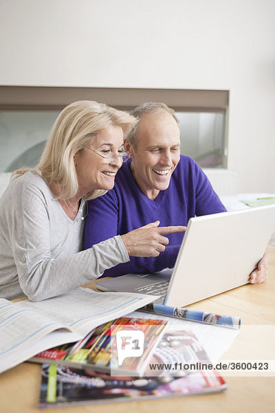 Couple looking at a laptop and smiling