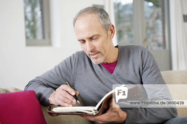 Man writing in a personal organizer