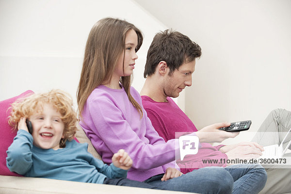 Family sitting together involved in different activities