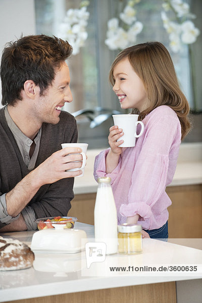 Man drinking coffee with his daughter
