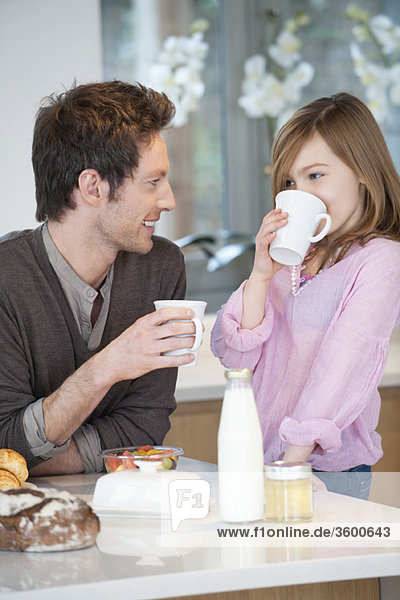 Mann trinkt Kaffee mit seiner Tochter