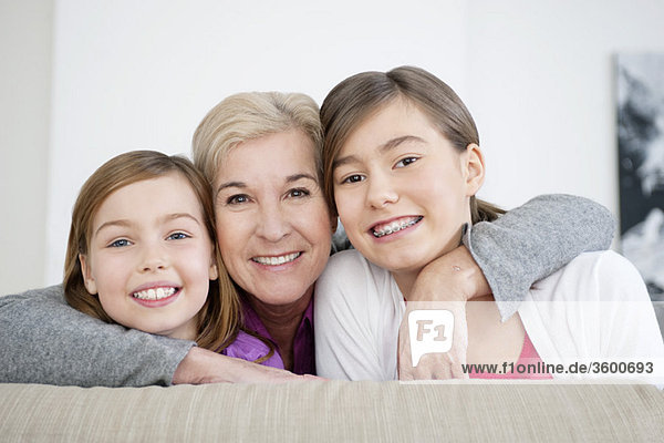 Porträt einer Frau  die mit ihren Enkelinnen lächelt