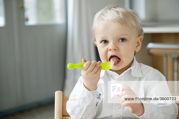 Portrait of a boy eating with a fork