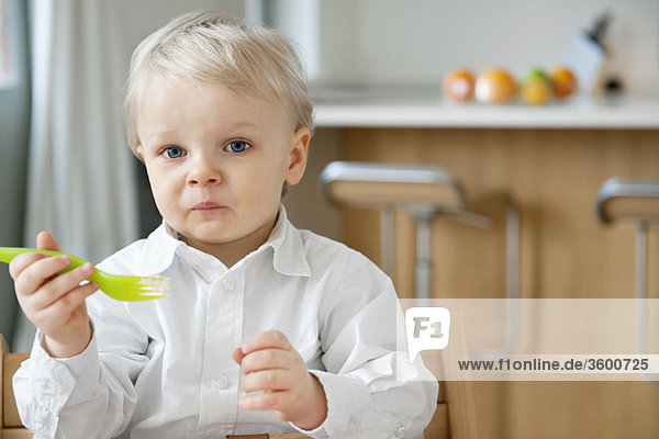 Boy eating with a fork and making a face