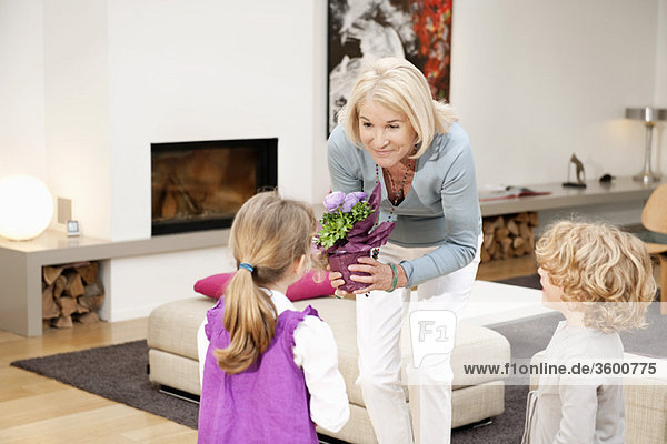 Woman giving a potted plant to her granddaughter