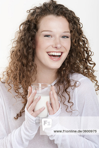 Porträt einer Frau  die ein Glas Milch hält und lacht