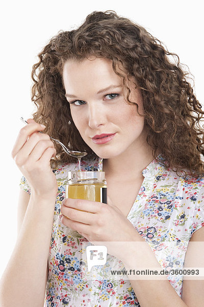 Portrait of a woman eating honey