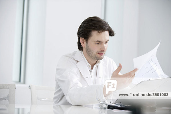 Male doctor examining a medical report