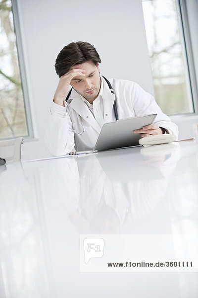 Male doctor examining a medical report and looking upset