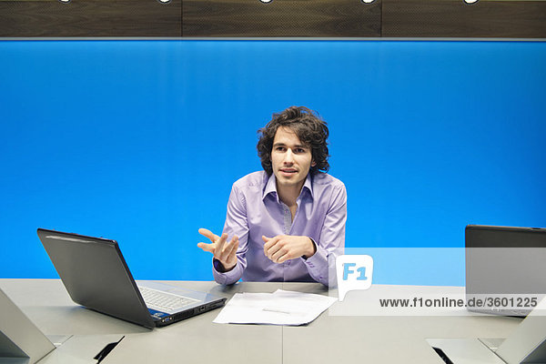 Businessman smiling with a laptop in a conference room