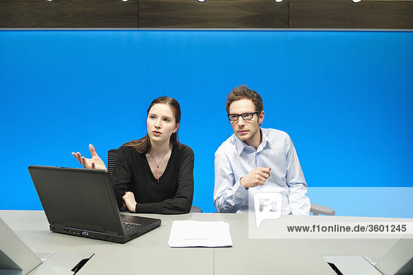 Business executives working on a laptop in a conference room