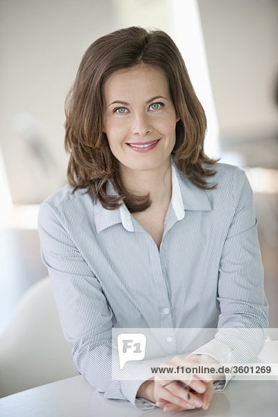 Businesswoman sitting at a table and smiling
