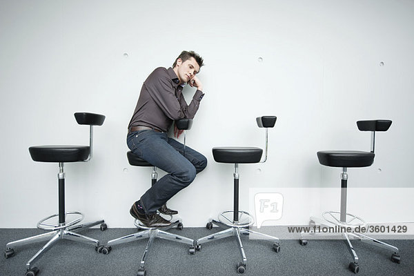 Geschäftsmann auf einem Stuhl sitzend und nachdenkend