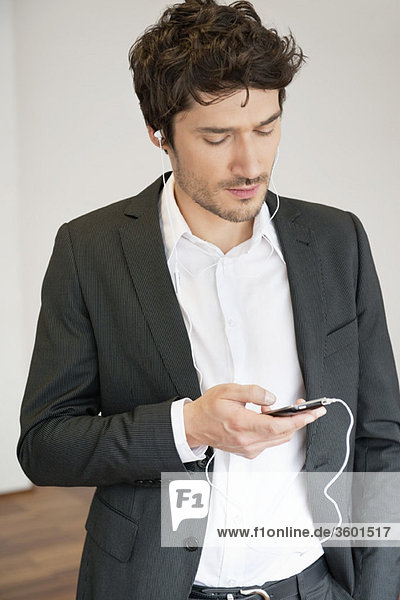 Businessman listening to music with a mobile phone