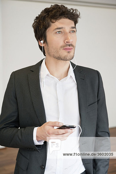 Businessman listening to music with a mobile phone