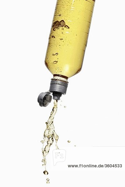 Gelber Energy Drink spritzt aus Flasche