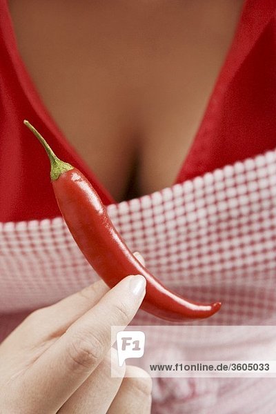 Frau hält rote Chilischote