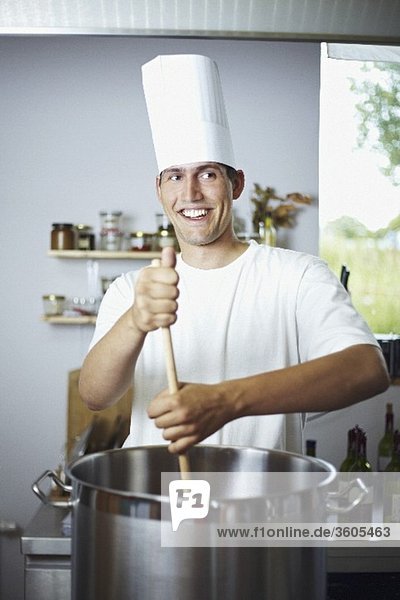 Laughing chef stirring pan