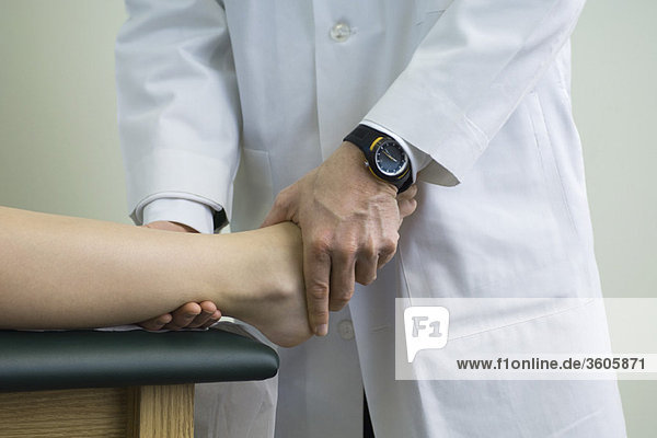 Doctor examining patient's feet and ankle