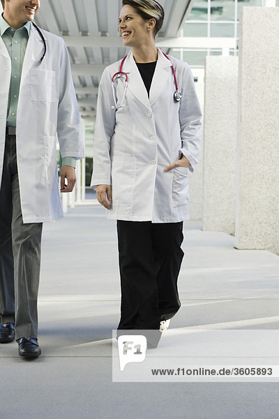 Ärztin geht mit Kollegin durch den Krankenhauskorridor