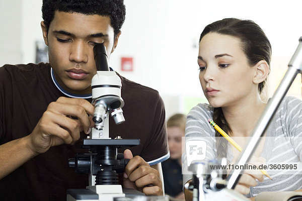 Student looking through microscope in science class