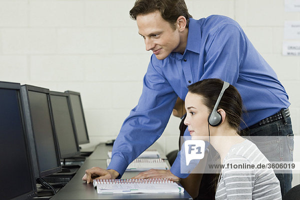 Lehrer assistiert Schüler im Computerlabor