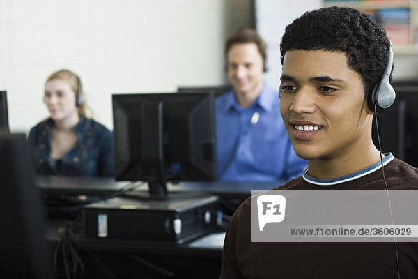 Student listening to headphones in computer lab