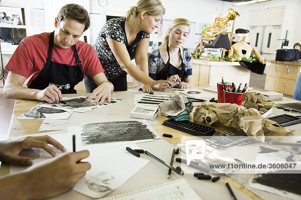 Kunstlehrer unterstützt Schüler mit Kohlezeichnungen