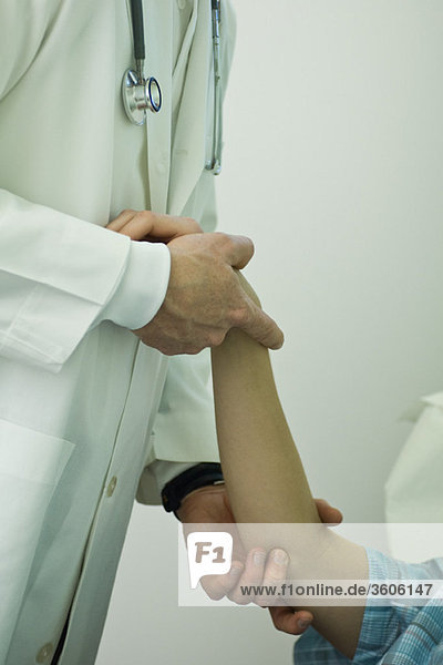 Doctor examining patient's arm