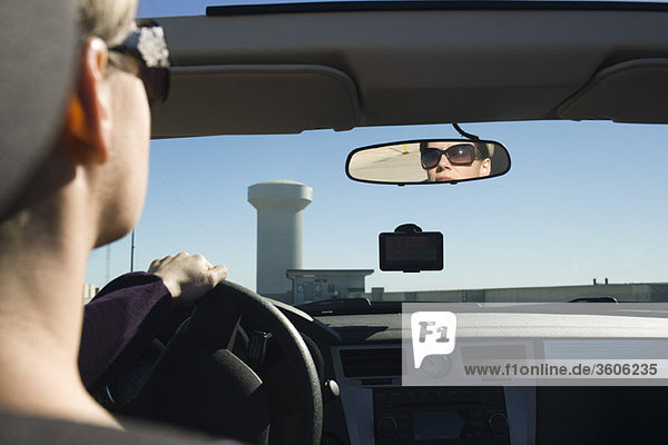Woman driving  reflection in rearview mirror