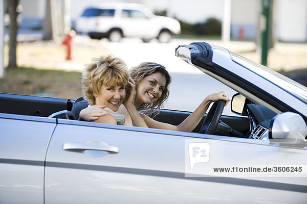 Mature woman out for drive with daughter in convertible