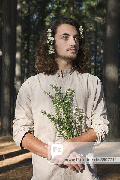 Mann mit Blumen im Wald