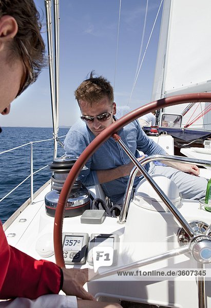 Men navigating yacht