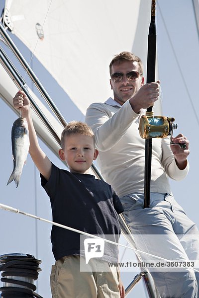 Father and son fishing on yacht