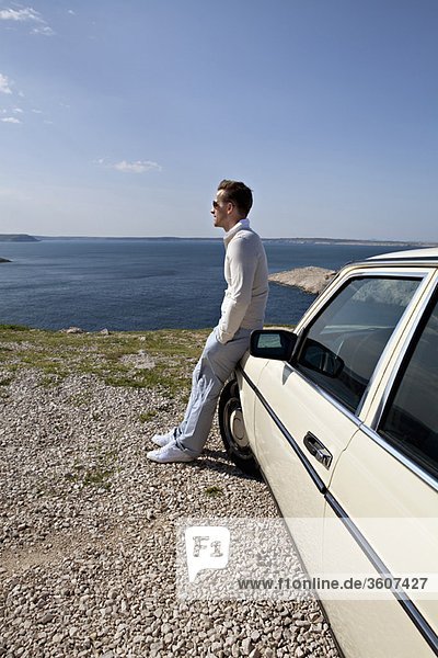 Man with oldtimer overlooking sea