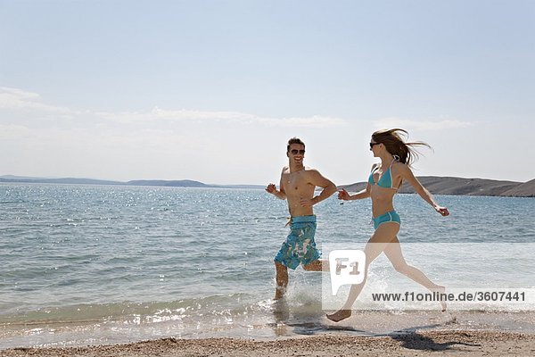 Paar läuft am Strand