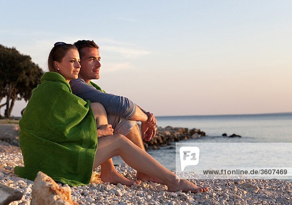Paar am Strand sitzend