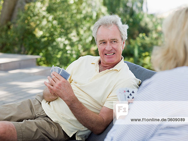 Mature couple playing cards outdoors