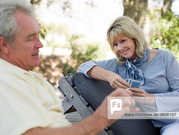Mature couple playing cards outdoors