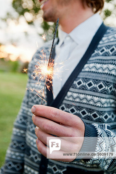 Young man holding a sparkler