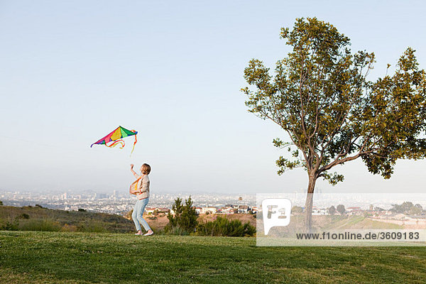 Young woman flying a kite in field