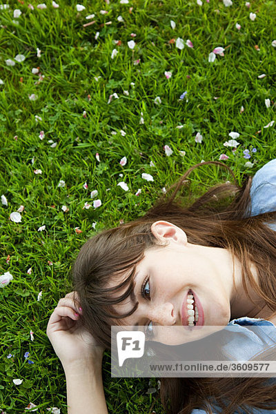 Junge Frau auf Gras liegend